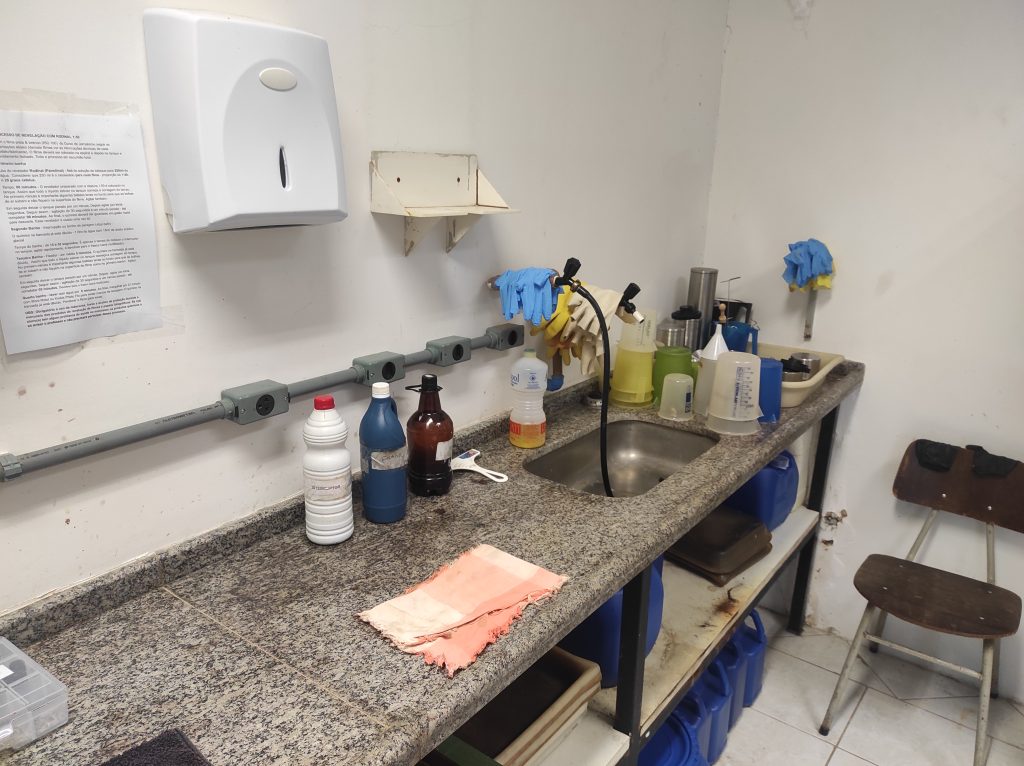 Pia do laboratório de fotojornalismo com frascos e outros equipamentos em volta