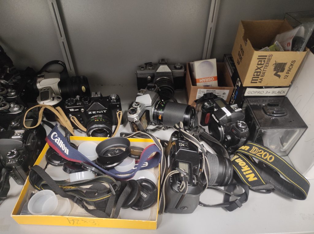 Conjunto de câmeras armazenadas no laboratório de fotojornalismo